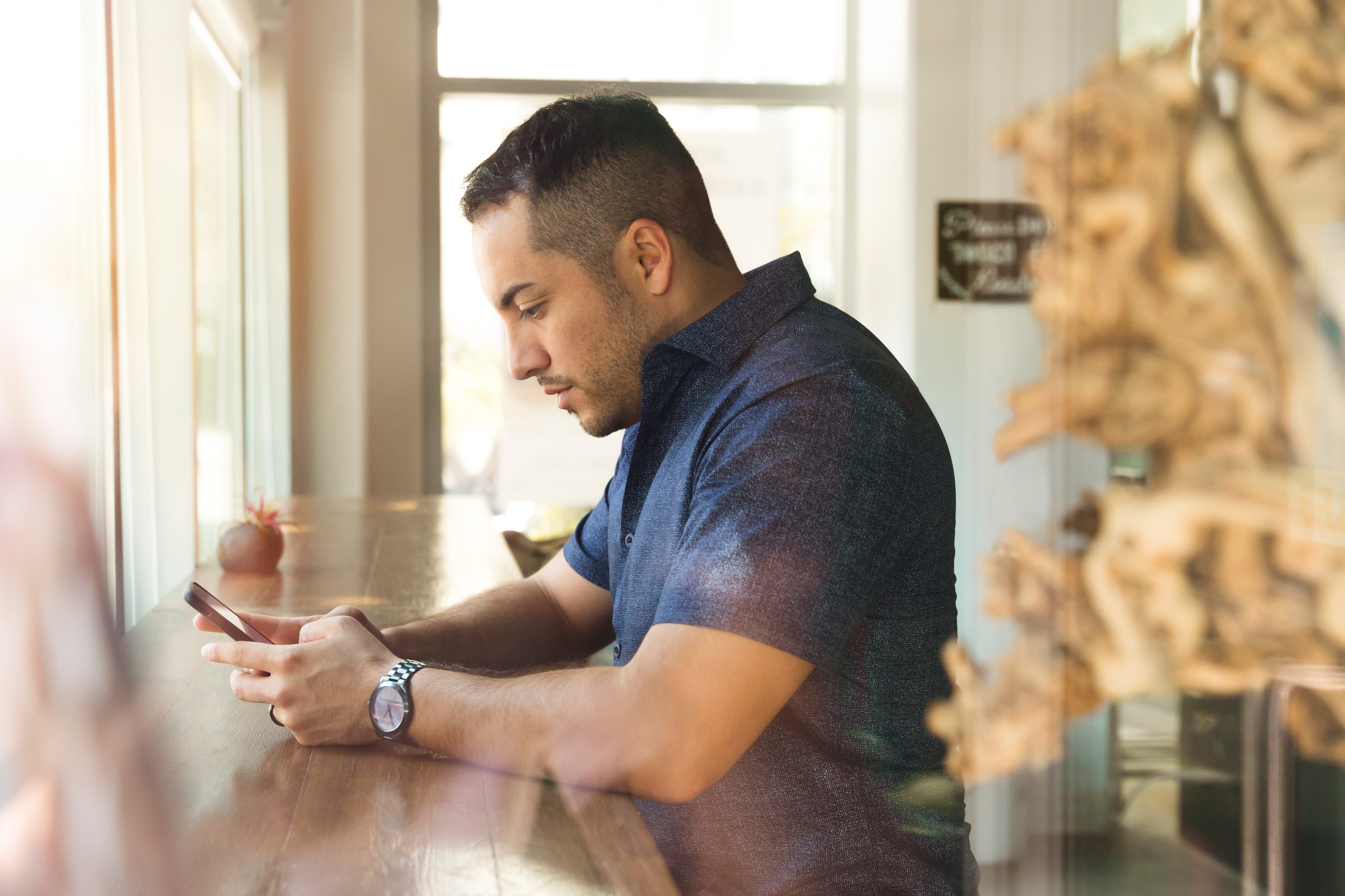 indoors, button, watching, real people, concentration, hands, looking down, contemplation, working, shirt, young adult, one person, sales pro, mobile phone, HD Wallpaper