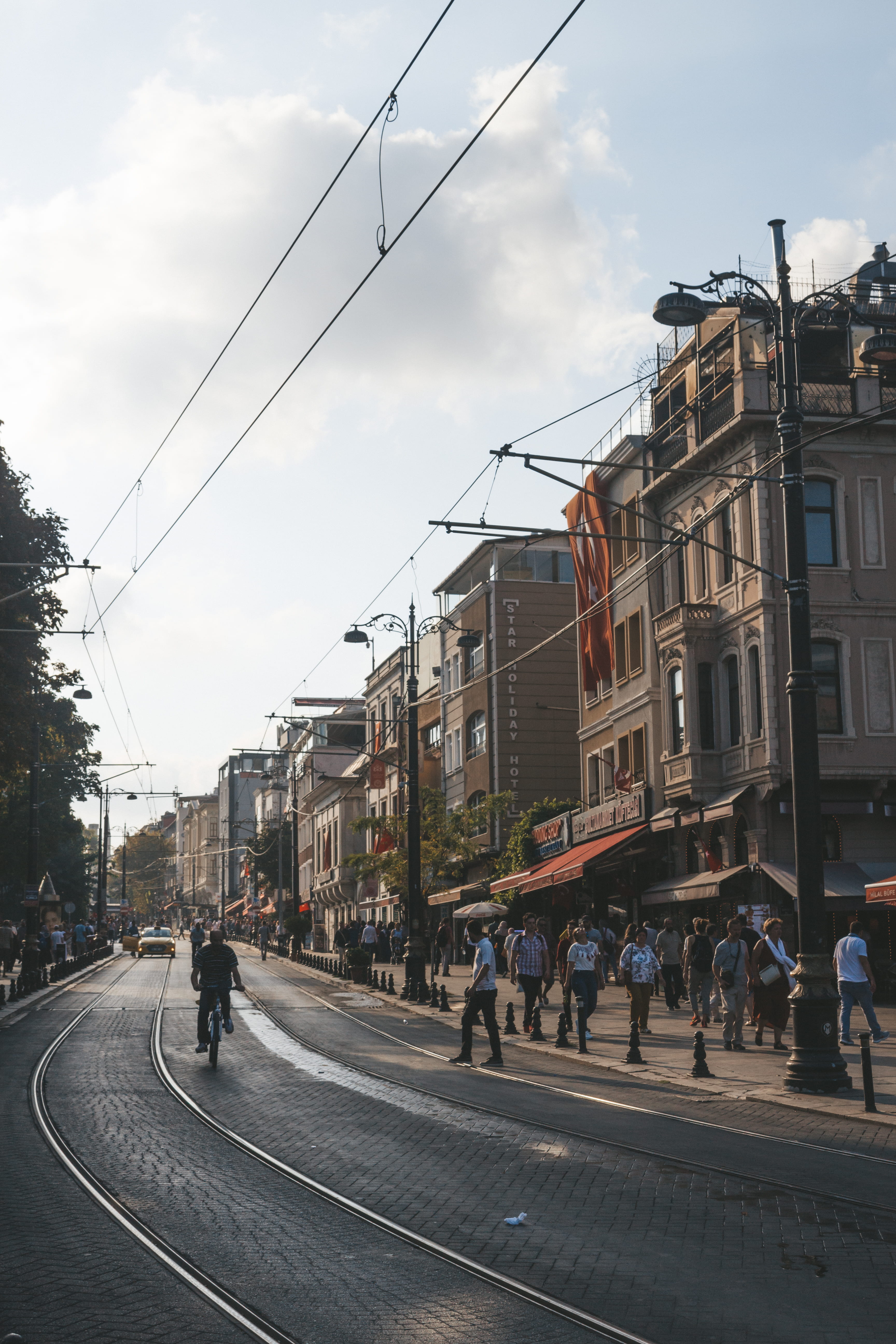 vehicle, group of people, city street, nature, buildings, building exterior, mode of transportation, building, lamppost, traffic, road, track, city, tram lines, Phone HD Wallpaper