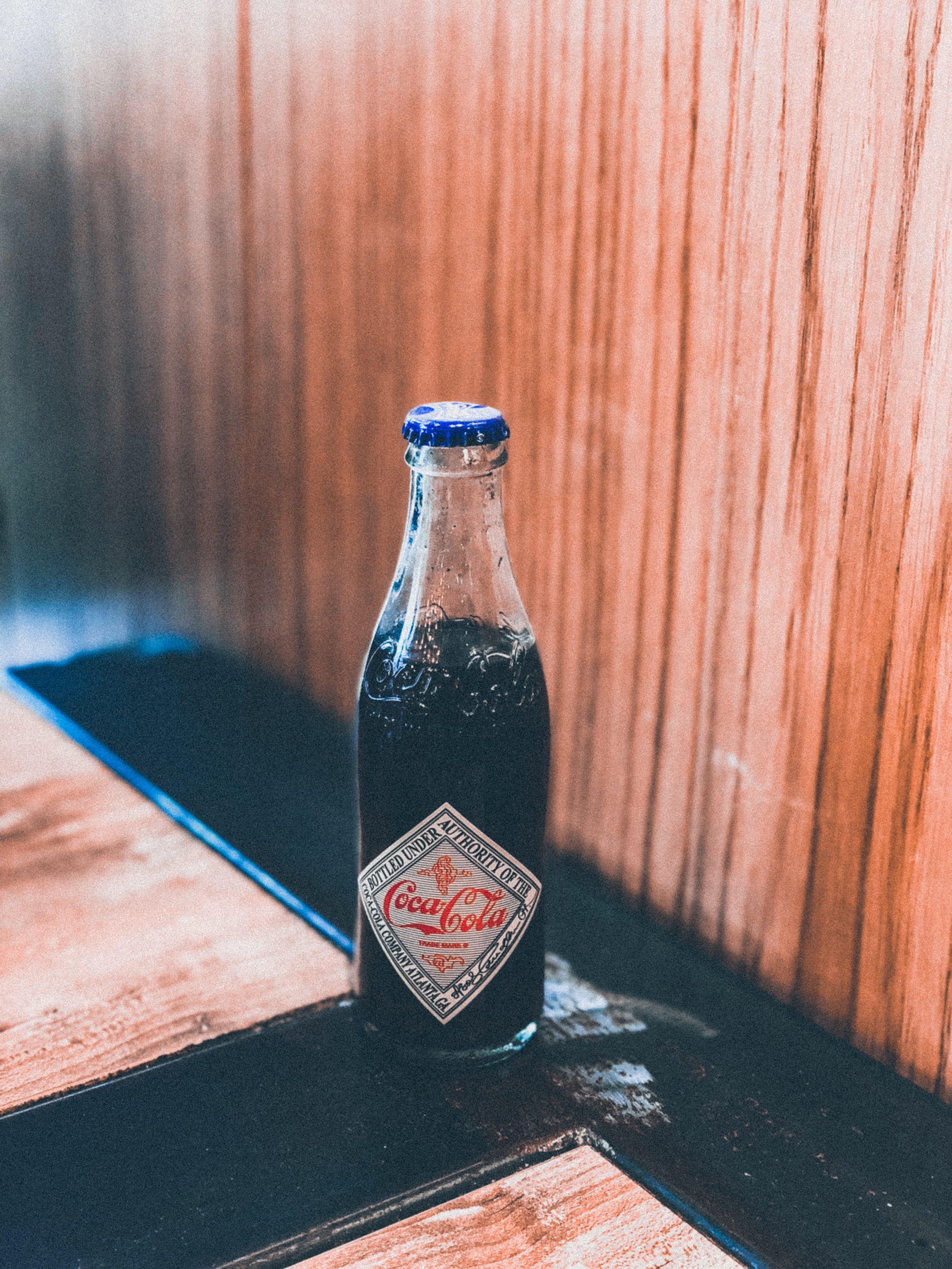 beer, black, close-up, trademark, nature, table, 4K, brown, wood, alcohol, liquor, coke, cola, still life, bottle, plywood, glass, transparent, indoors, Phone HD Wallpaper