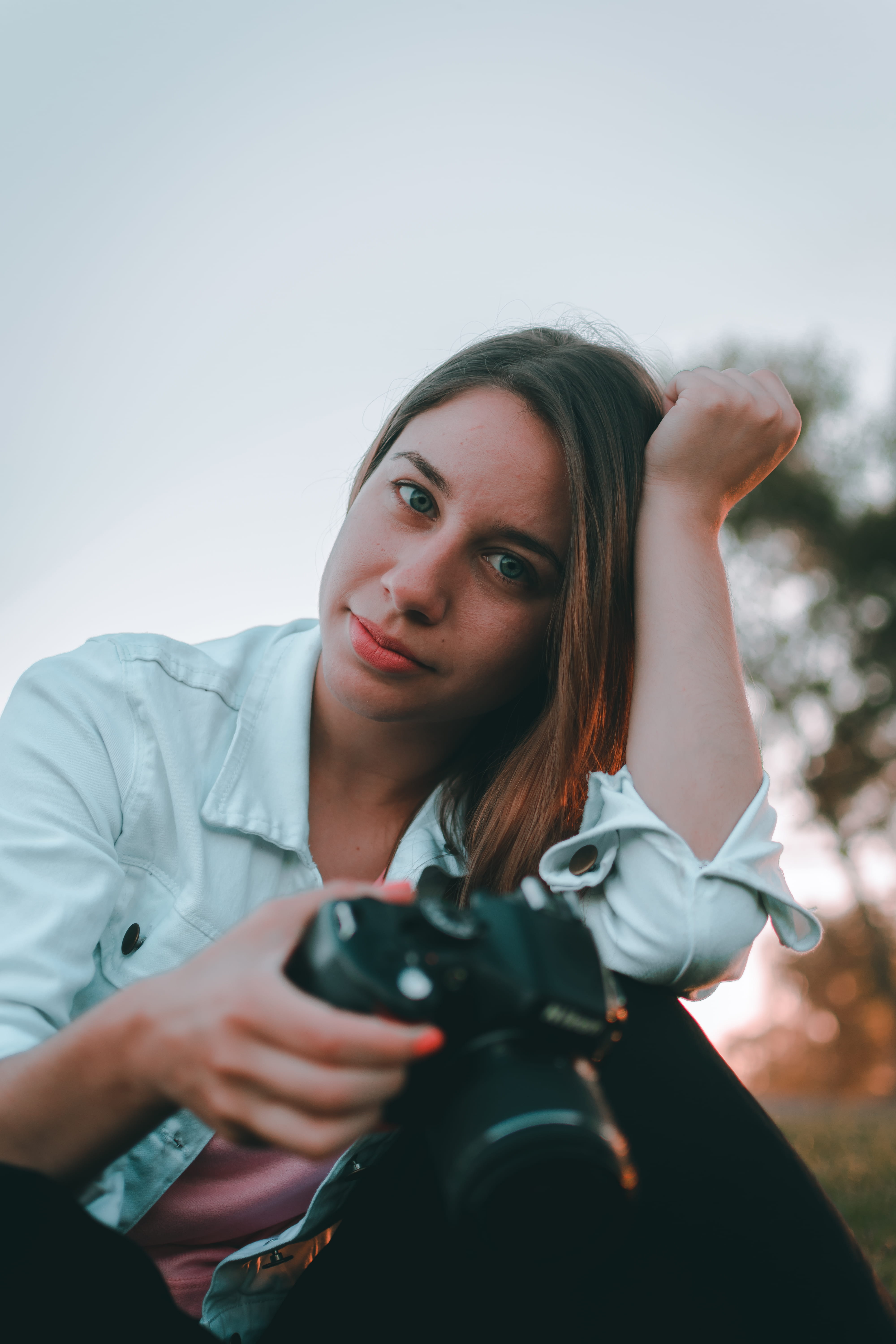 hair, woman, apparel, person, weaponry, planting, looking at camera, camera, real people, front view, sleeve, portrait, technology, sitting, leisure activities, Phone HD Wallpaper