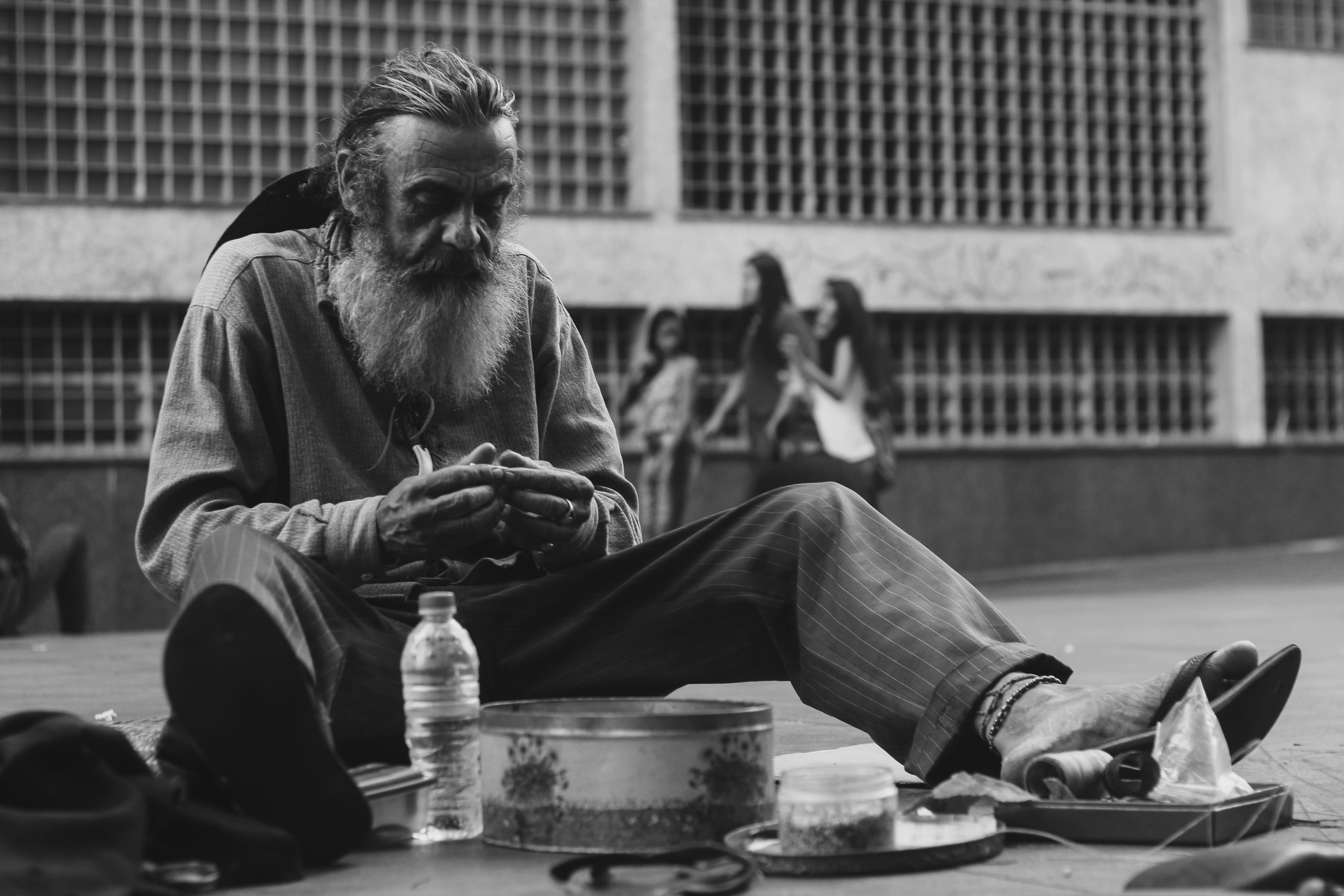 person, grayscale, focus on foreground, real people, building exterior, ground, people, container, built structure, leisure activity, city, bottle, sitting, HD Wallpaper