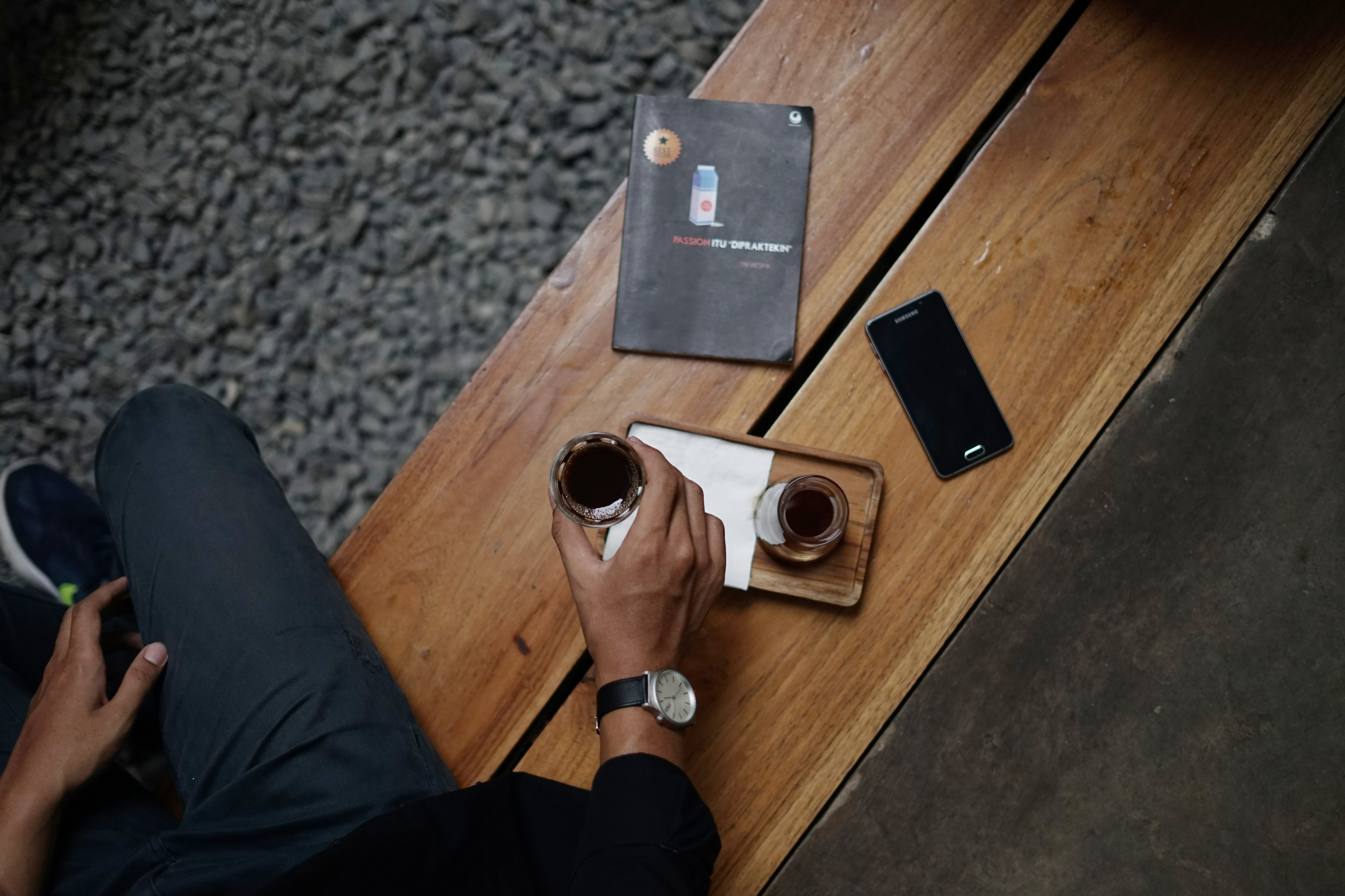 adult, metal, book, bench, plane, phone, design, sharpener, glass, device, flooring, 5K, table, coffee shop, technology, hand, polaroid camera, human hand, HD Wallpaper