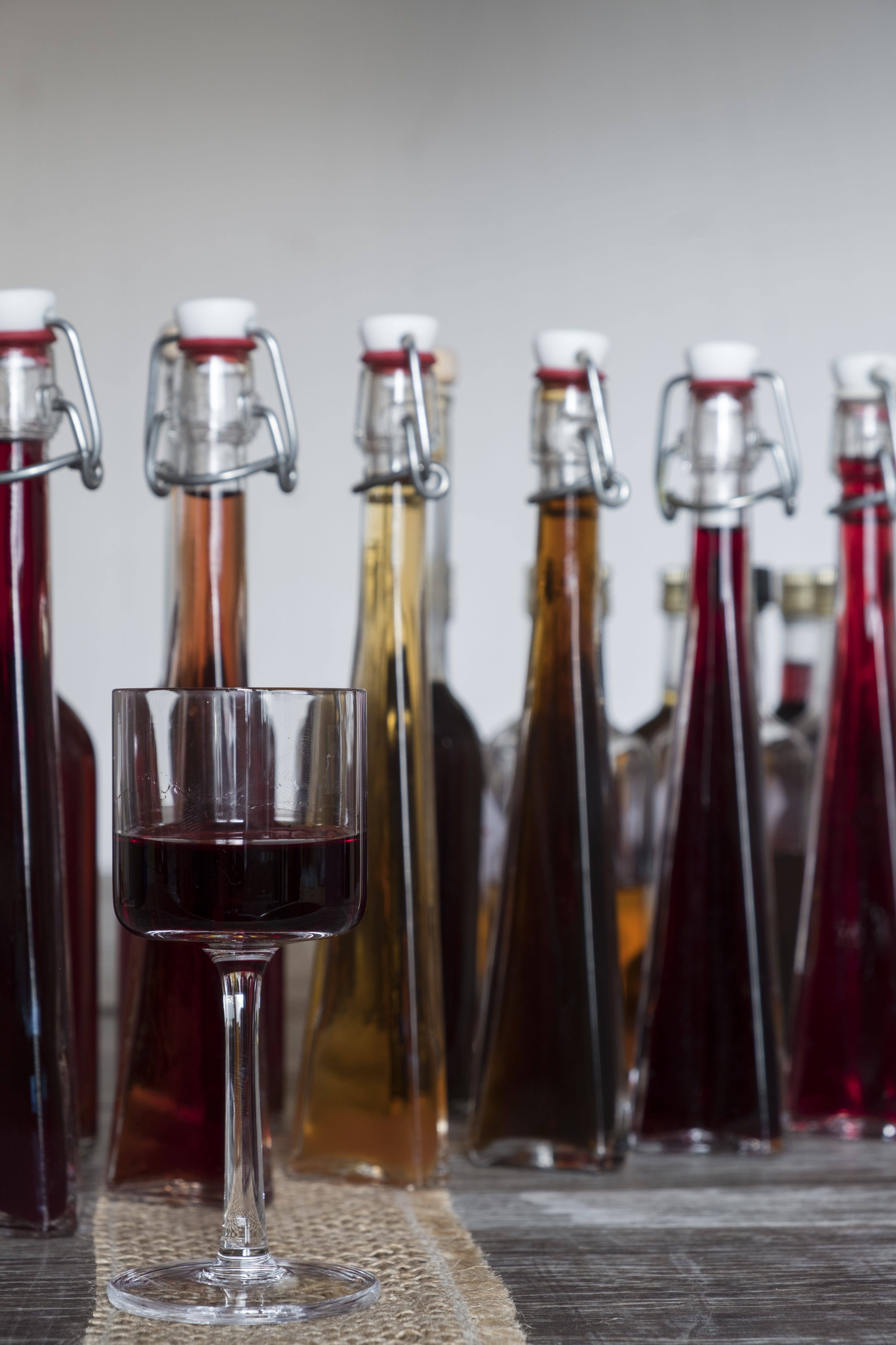 in a row, alcohol, refreshment, brandy, bottles, transparent, royal, bottle, glass, bar counter, indoors, 5K, still life, alcoholic, no people, freshness, Phone HD Wallpaper