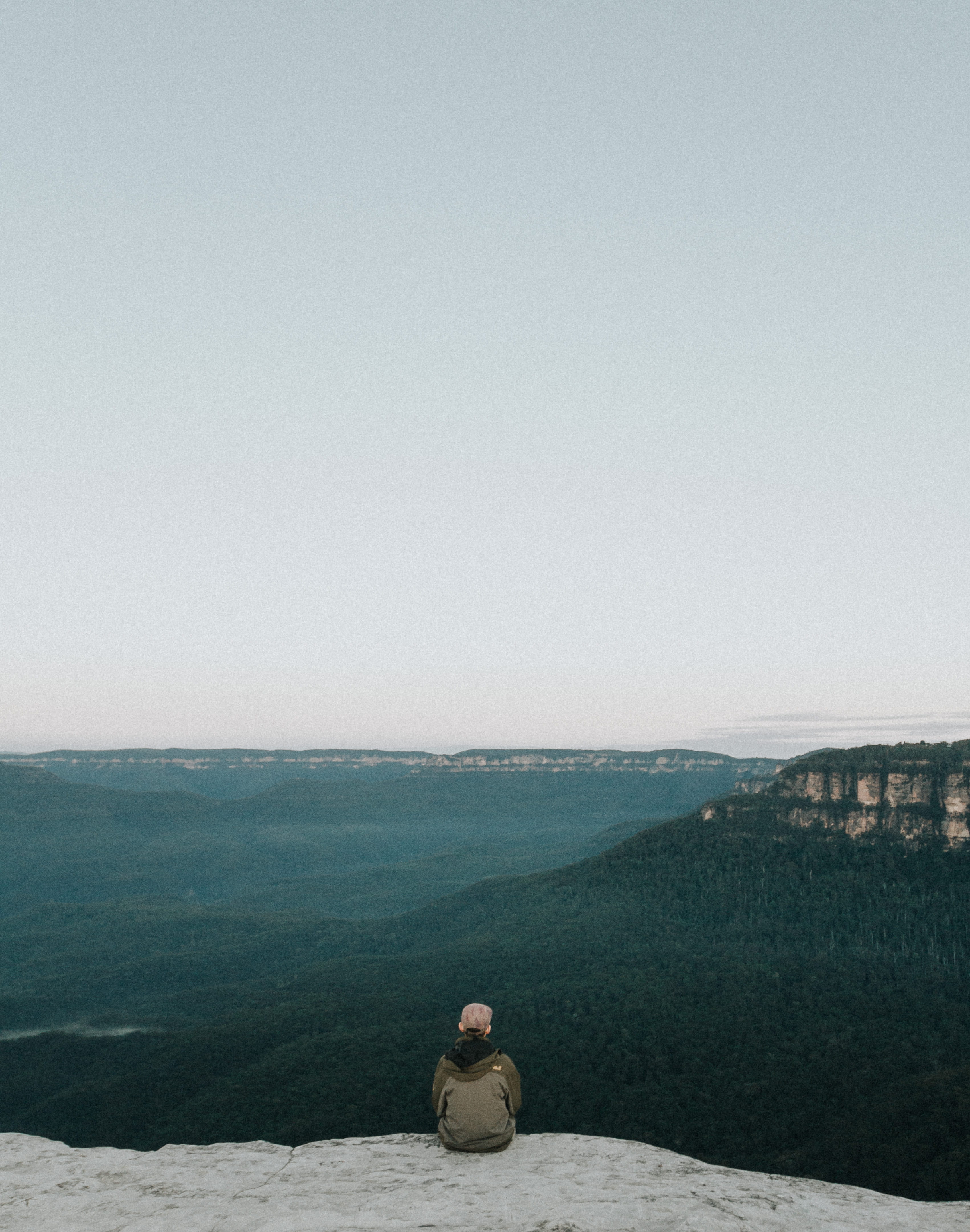 cliff, perosn, sit, color Image, water, ledge, clear sky, sitting, sea, leisure activity, Looking Out, rock, adults only, person, nature, non-urban scene, Phone HD Wallpaper