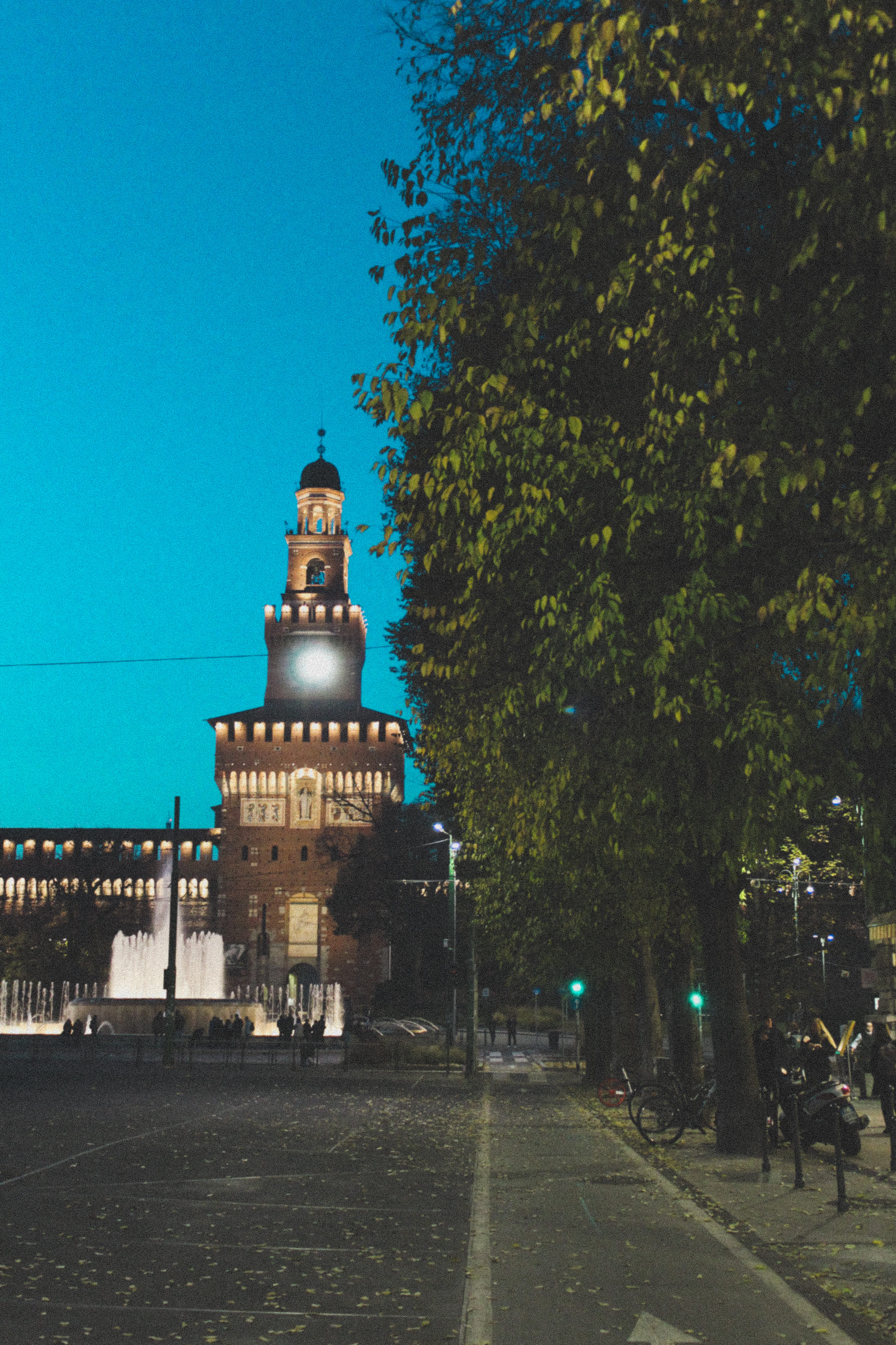 plant, fountain, 5K, tree, milano, nature, blue, road, architecture, sforzesco castle, outdoors, incidental people, city, building, direction, illuminated, Phone HD Wallpaper