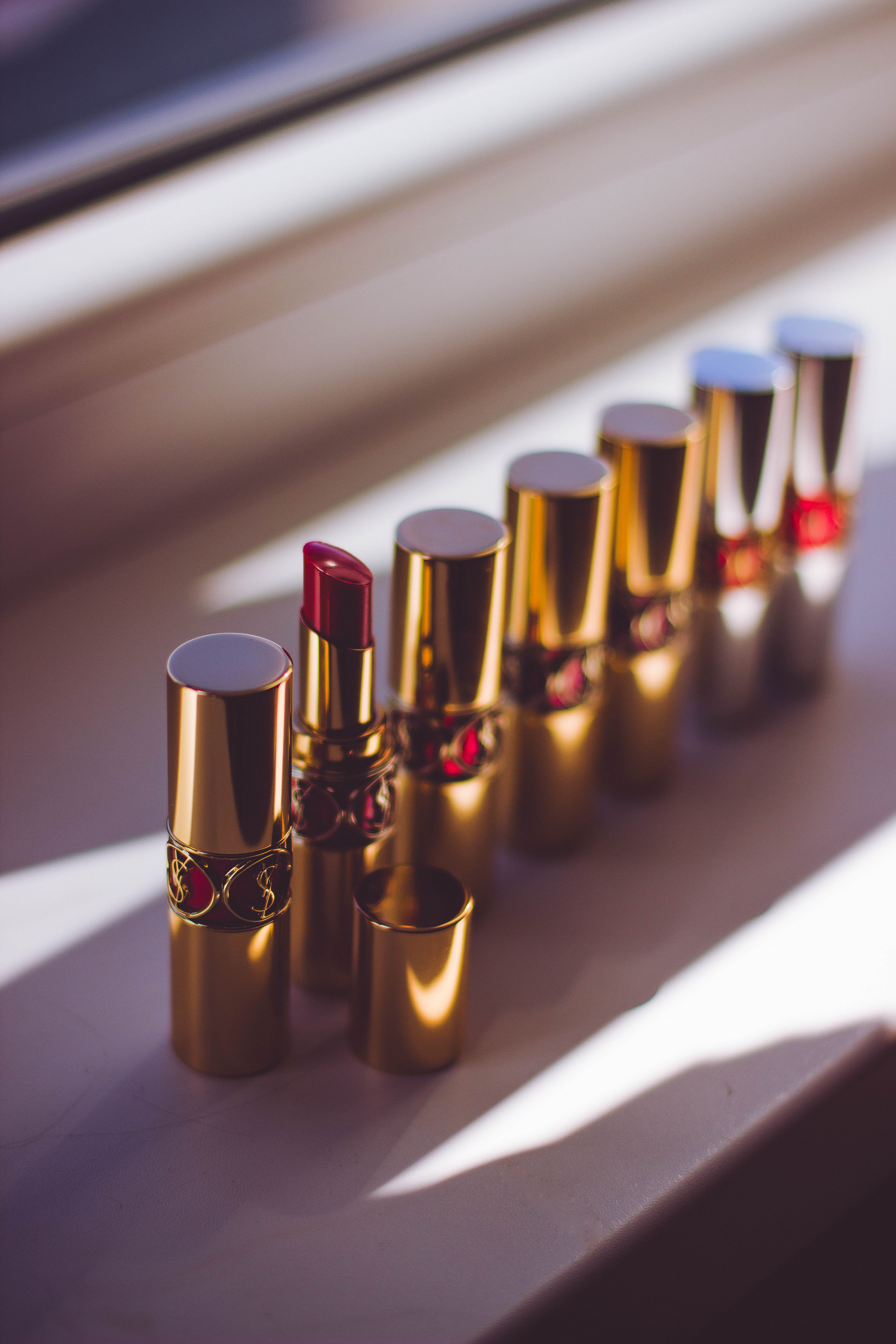 lipstick, musical instrument, lipstick tubes, table, red, sunlight, 5K, makeup, glass, shadow, day, arrangement, side by side, close-up, music, selective focus, Phone HD Wallpaper