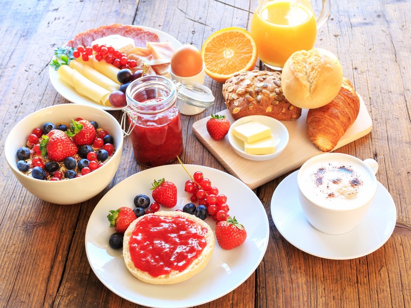 food, breakfast, orange (fruit), strawberries, blueberries, bread, jelly, coffee, eggs