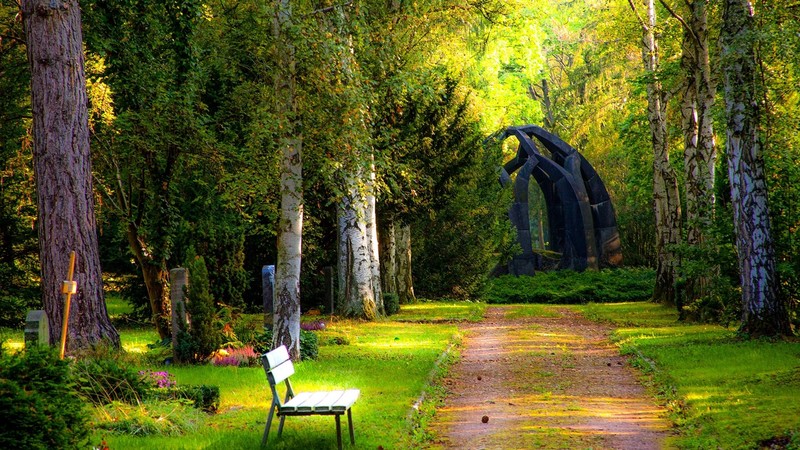 park, trees, plants, bench, dirt road, grass, monuments