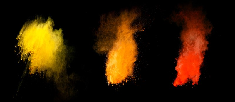 powder explosion, powder, black background, colorful, yellow, orange, red
