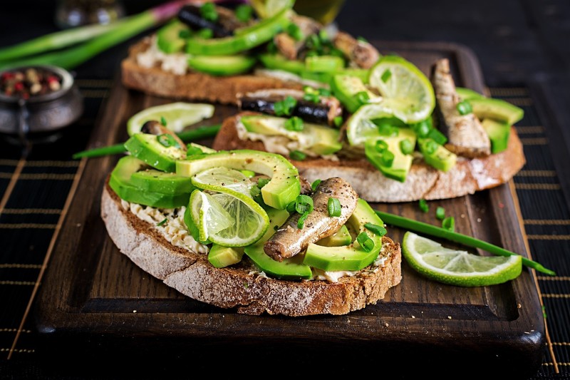 food, fish, bread, vegetables, cutting board, avocados, limes