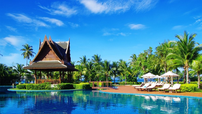 swimming pool, water, palm trees, sky blue, clouds, building, umbrella, sunbed, nature