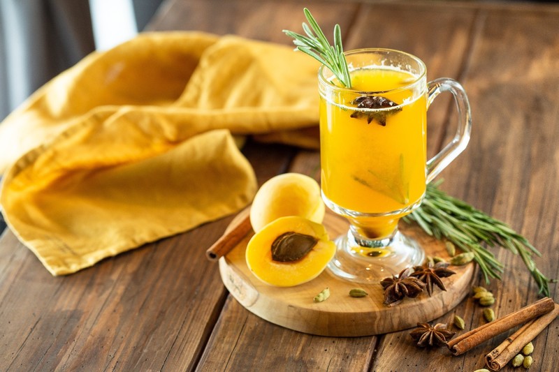 food, fruit, still life, drinking glass, juice, rosemary, cinnamon, star anise, apricots, cutting board, napkin, wooden surface, yellow