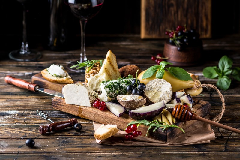 food, still life, cheese, fruit, berries, grapes, basil, red currant, bread, honey, knife, cutting board, wooden surface, wine, drinking glass