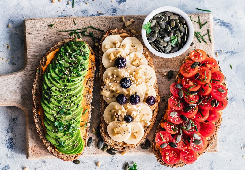 food, bread, bananas, avocados, tomatoes, cutting board, blueberries