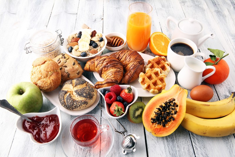 food, breakfast, fruit, coffee, tea, orange (fruit), wooden surface, apples, bananas, kiwi (fruit), honey, eggs, waffles, croissants, Jam, oatmeal, nuts, strawberries, raspberries, blueberries