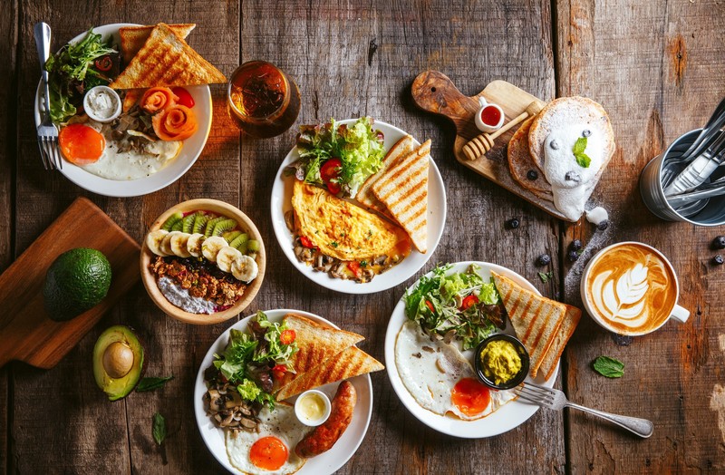 food, still life, bread, vegetables, eggs, kiwi (fruit), avocados, coffee, fork, tea, knives, omelete