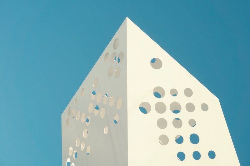 unique design on a white building with holes in denmark, swiss cheese architecture 4k