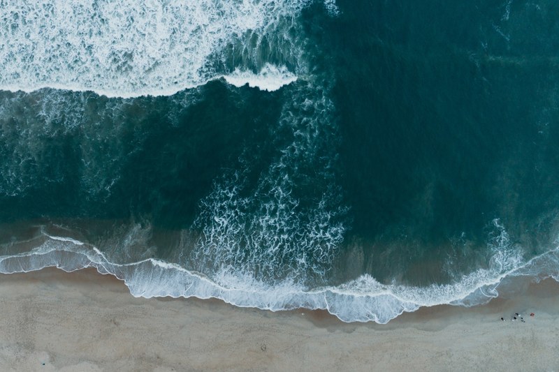 drone view of the ocean washing on the sand beach shore at nags head north carolina united states, sea washing ashore drone view 4k