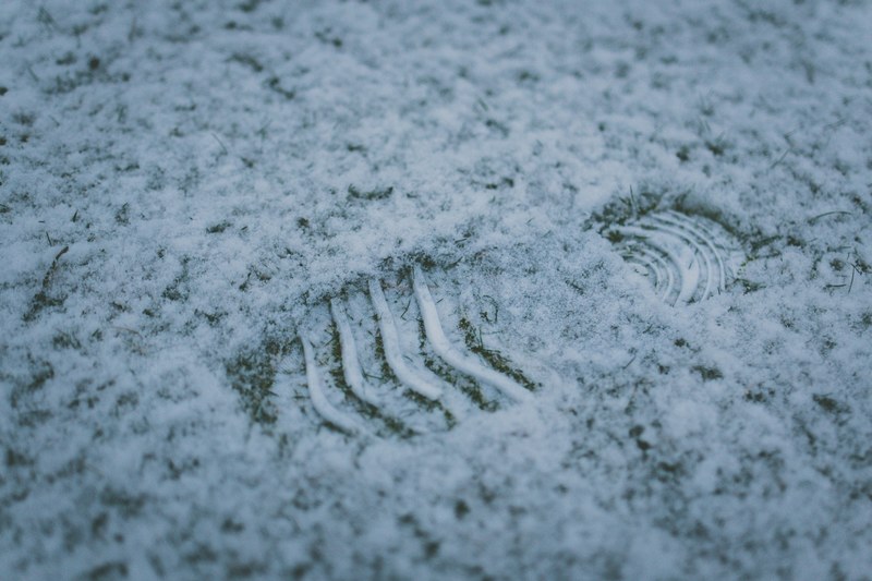 a footprint on a light layer of snow in the grass, a footprint in the snow 4k