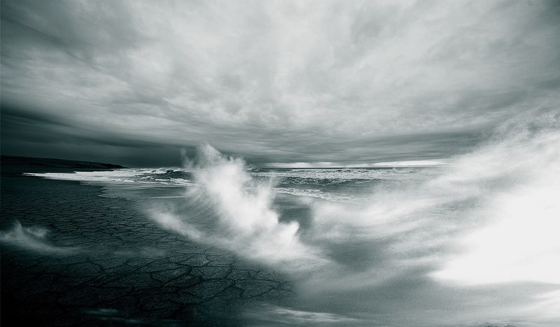 white capped sea waves breaking on a barren shore on a stormy day, waves 4k