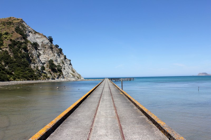 a long concrete jetty along a rocky coast, long jetty 4k