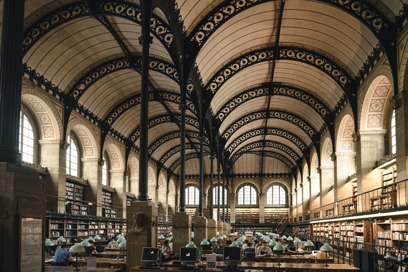 a beautiful library with arches and bookshelves in paris, parisian library 4k