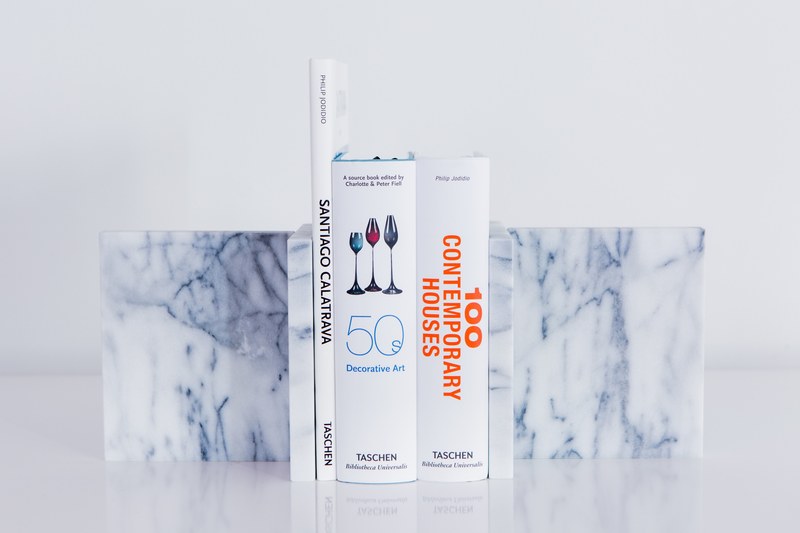 three books in a marble bookend on a white surface, marble bookend 4k