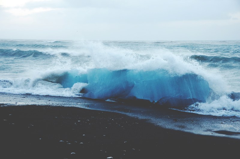 tall sea waves splashing against an empty beach, ice blue waves 4k