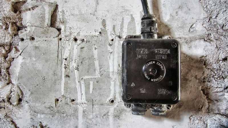 old black electric box situated on a gray concrete wall, electricity box 4k