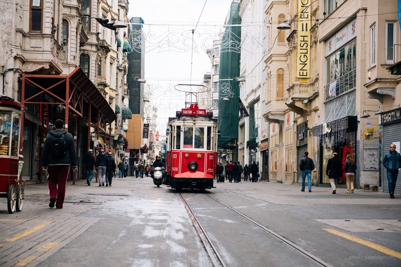 red cable car in road with people and buildings on either side, red cable car in city 4k