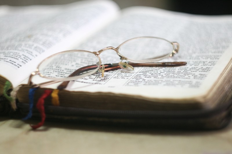 a pair of reading glasses on top of a book, _reading glasses open book 4k