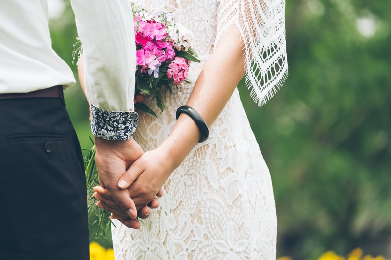 bride with pink bouquet and lace dress hold hands with groom, bride and groom hold hands 4k