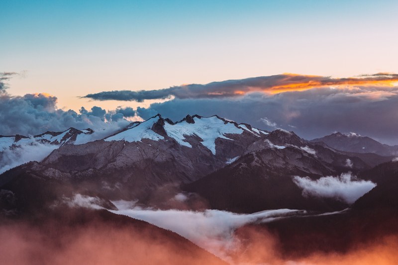 snow covered mountains shrouded in mist and clouds, snowy mountains at dusk 4k