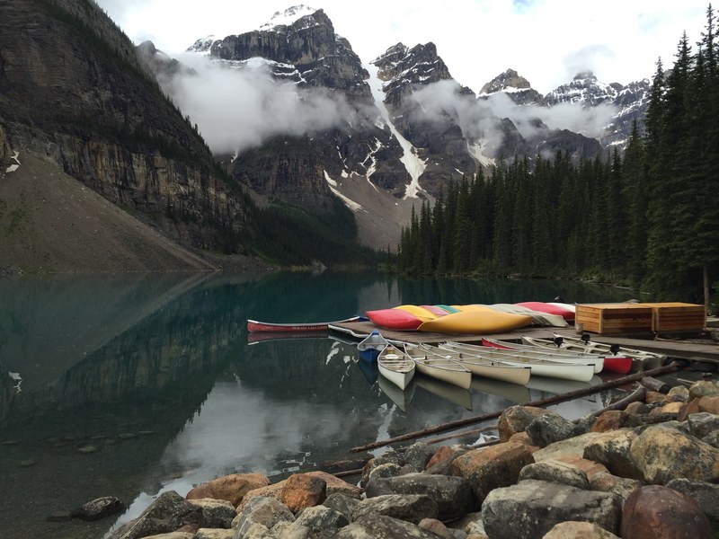 a large number of kayaks and canoes moored at a pier on a lake, kayaks and canoes on a lake 4k