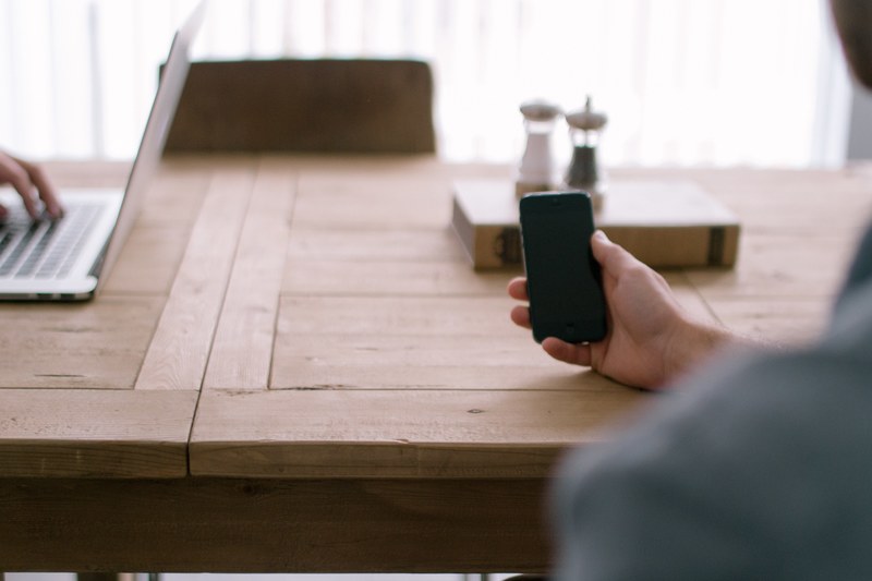 a display of smartphone technology device and laptop on a wooden table, device and laptop on a table 4k