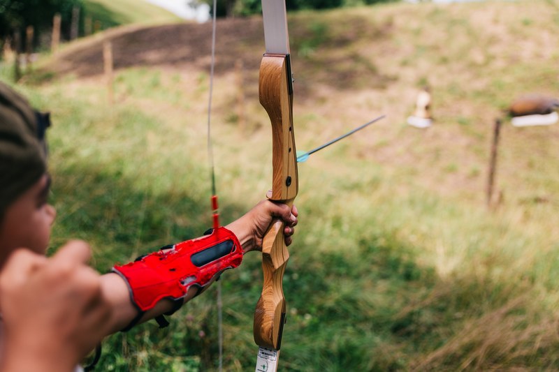 person holds bow and arrow and aims at target, focus 4k