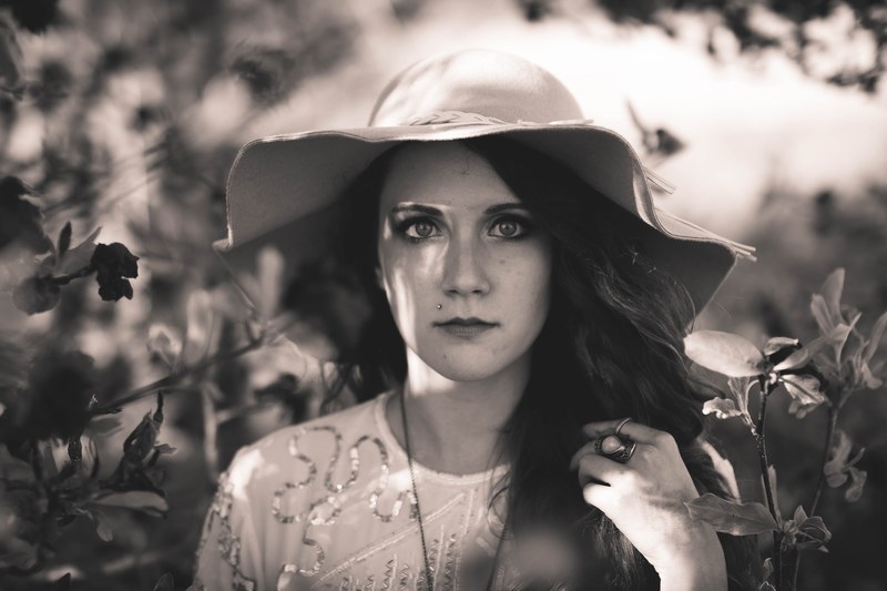 black and white shot of attractive dark haired woman in large floppy hat amongst plants benton, floppy hat and plants 4k