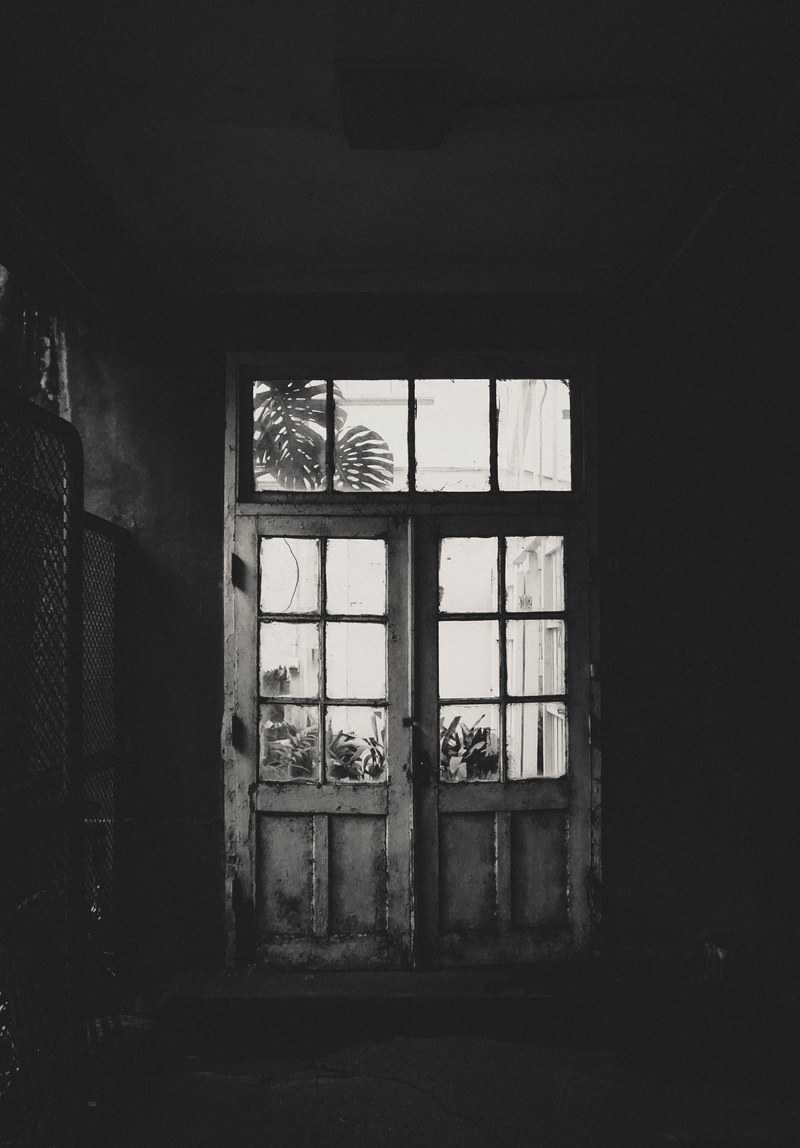 abandoned interior of a house showing a white run down door leading outside, white door 4k