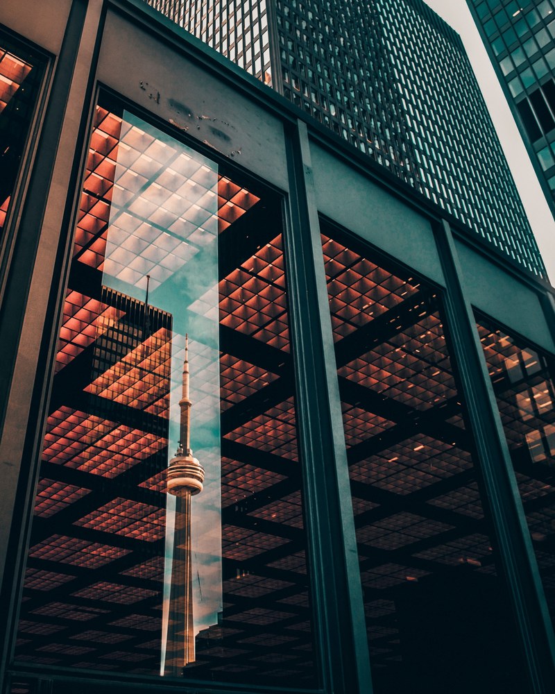 the cn tower in toronto reflected in the window of a nearby building, reflect 4k