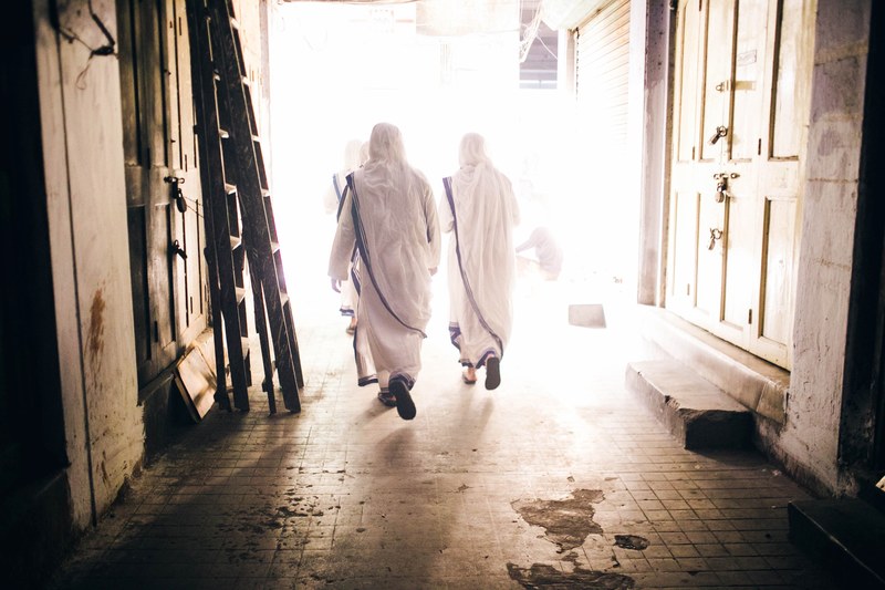 two men dressed in white walking on a bright street, _entering the light 4k