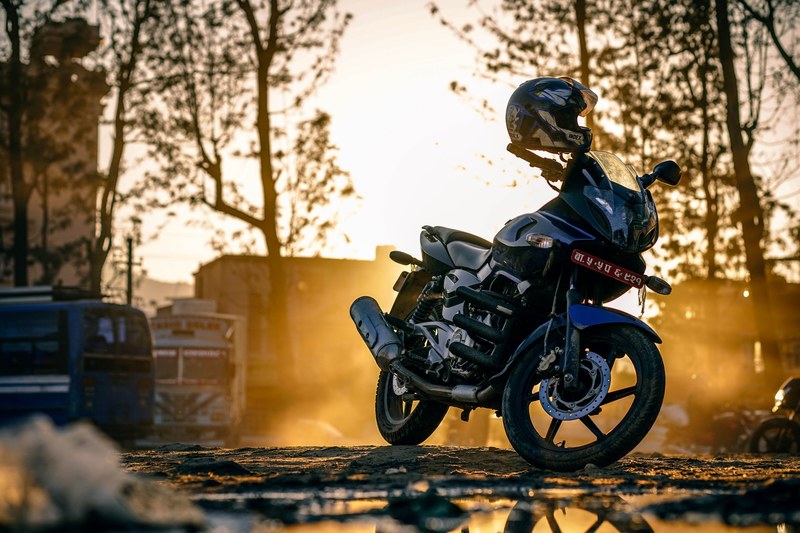 a motorcycle parked on a roadside in kathmandu at sunset, parked motorcycle 4k