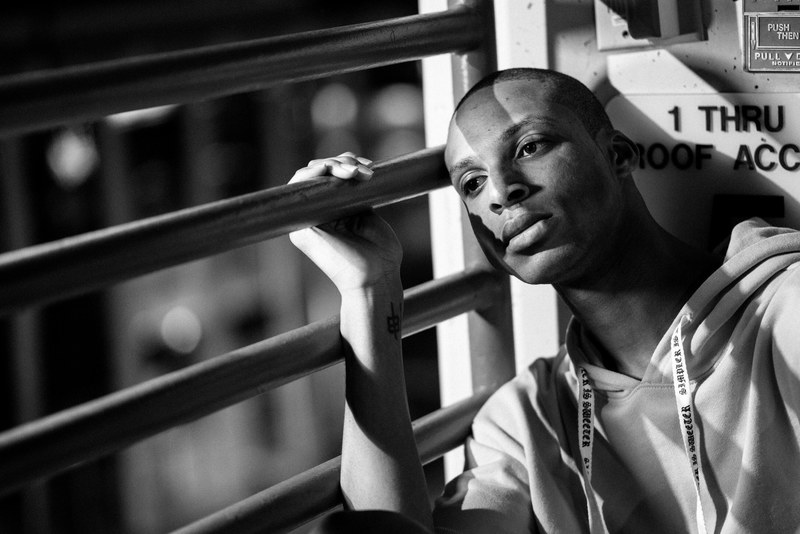 black and white portrait in thought and leaning against railing 4k