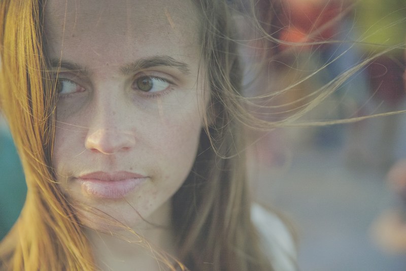young womans face with hair blown by the wind at fort myers beach, young womans face 4k
