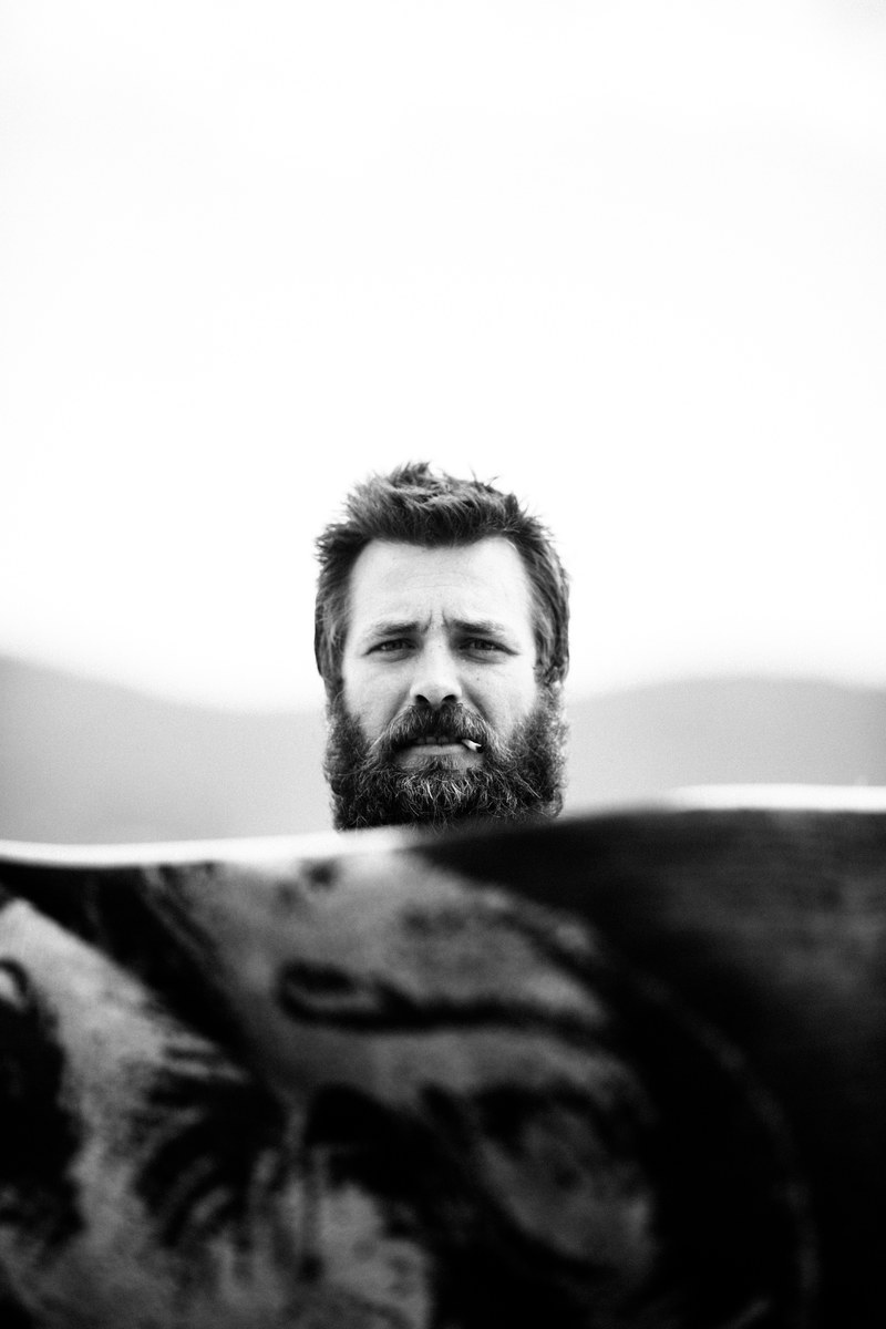 black and white portrait of a bearded man smoking a cigarette at blueys beach, the misadventures of an ill spent youth 4k