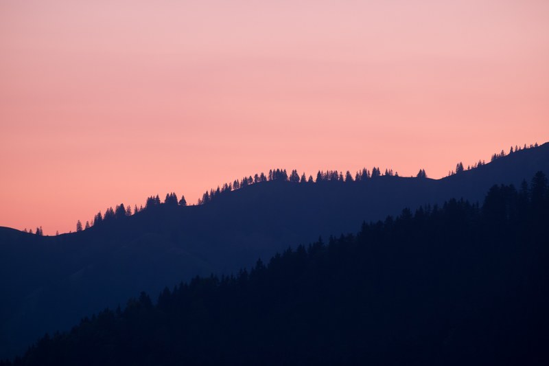 wooded hills silhouetted against orange hued sky in veytaux, just before sunrise 4k