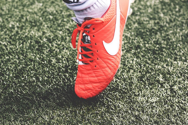 a close up shot of a male wearing a red pair of mens running shoes, mens red nike shoes 4k