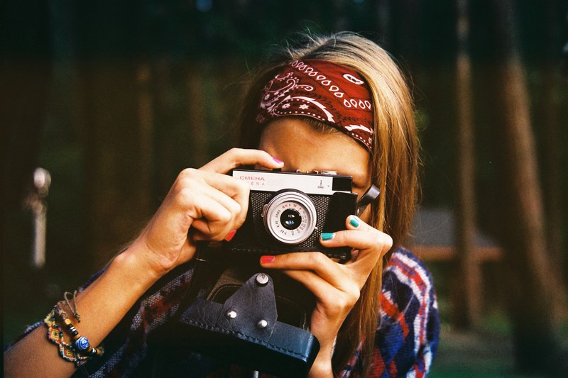 a woman in a red bandana tie dye shirt and bright nail polish takes a photo, smena kamera 4k
