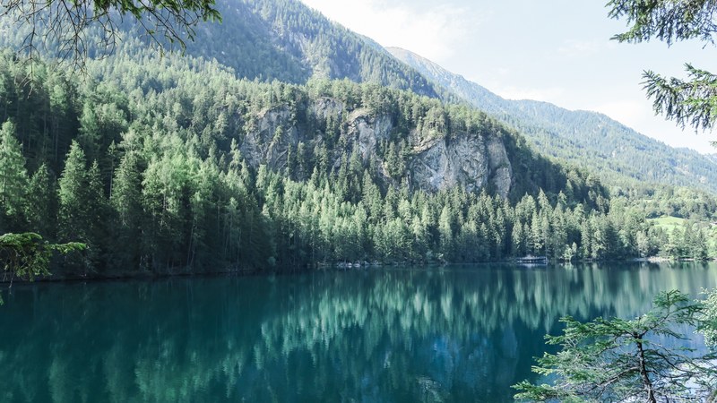 rock formations on the shore of lake piburger see on a bright day, rock face near a lake 4k