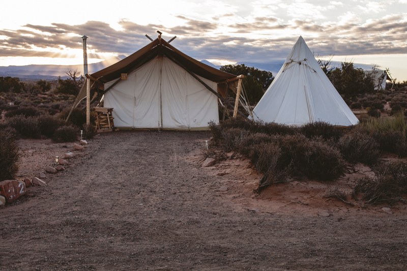 rural campsite with a tent and teepee in a barren landscape, rural campgrounds 4k