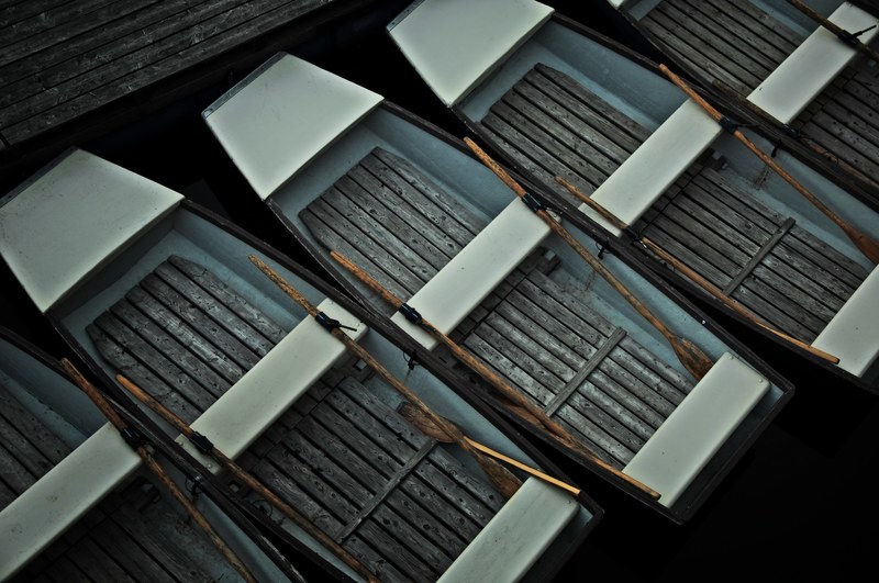 an overhead shot of wooden boats with oars inside moored at a jetty, row of wooden boats 4k